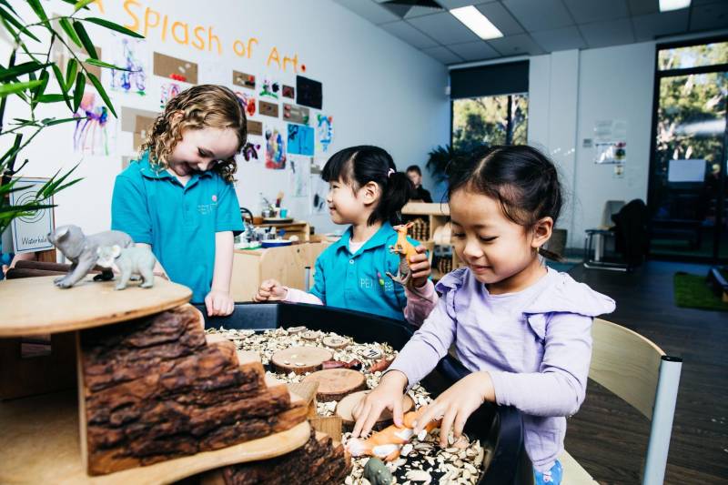 Children play around an Australian animal themed sensory table. TITLE: