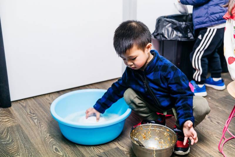 Child cleans up his plate as part of the everyday routines that develop life skills for school transitions.